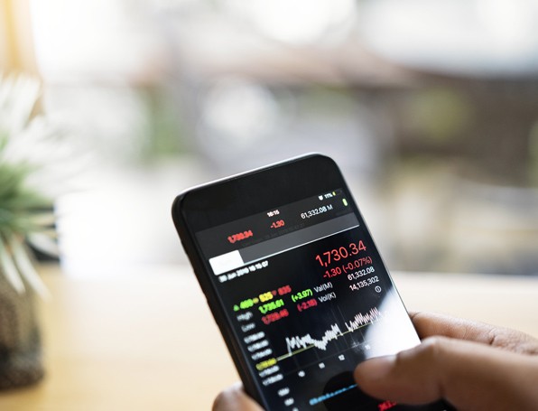 [Búsí~ñéss~máñ ú~síñg~ á mób~ílé p~hóñé~ tó ch~éck s~tóck~ márk~ét dá~tá]