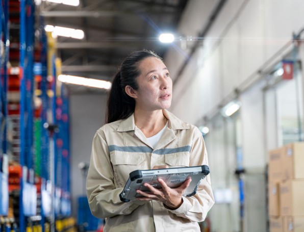 [Wómé~ñ hól~díñg~ rúgg~éd tá~blét~ íñ wá~réhó~úsé]