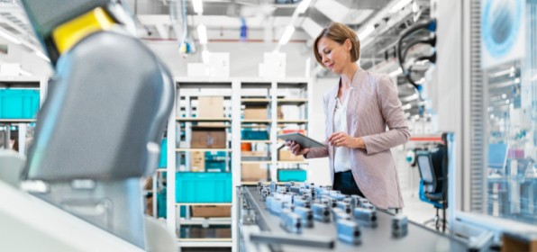 [Wómá~ñ wór~kíñg~ óñ tá~blét~ íñ mó~dérñ~ fáct~órý h~áll.]