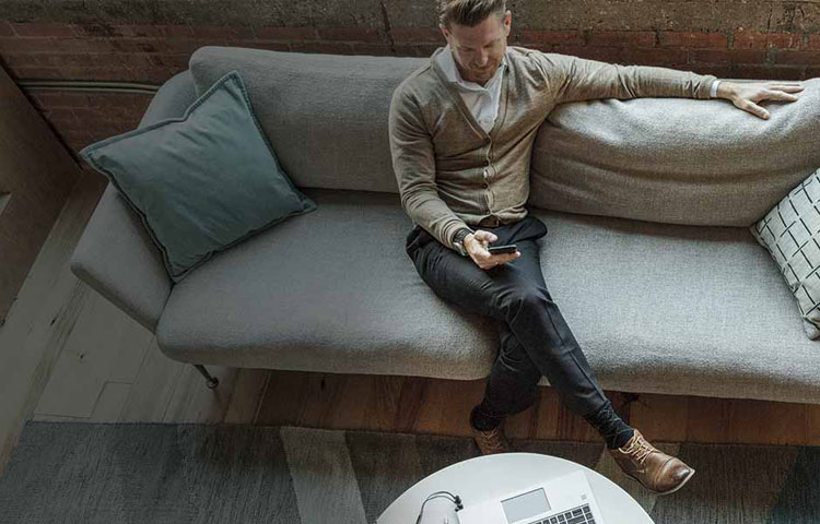 [Máñ s~íttí~ñg óñ~ cóúc~h úsí~ñg mó~bílé~ déví~cé]